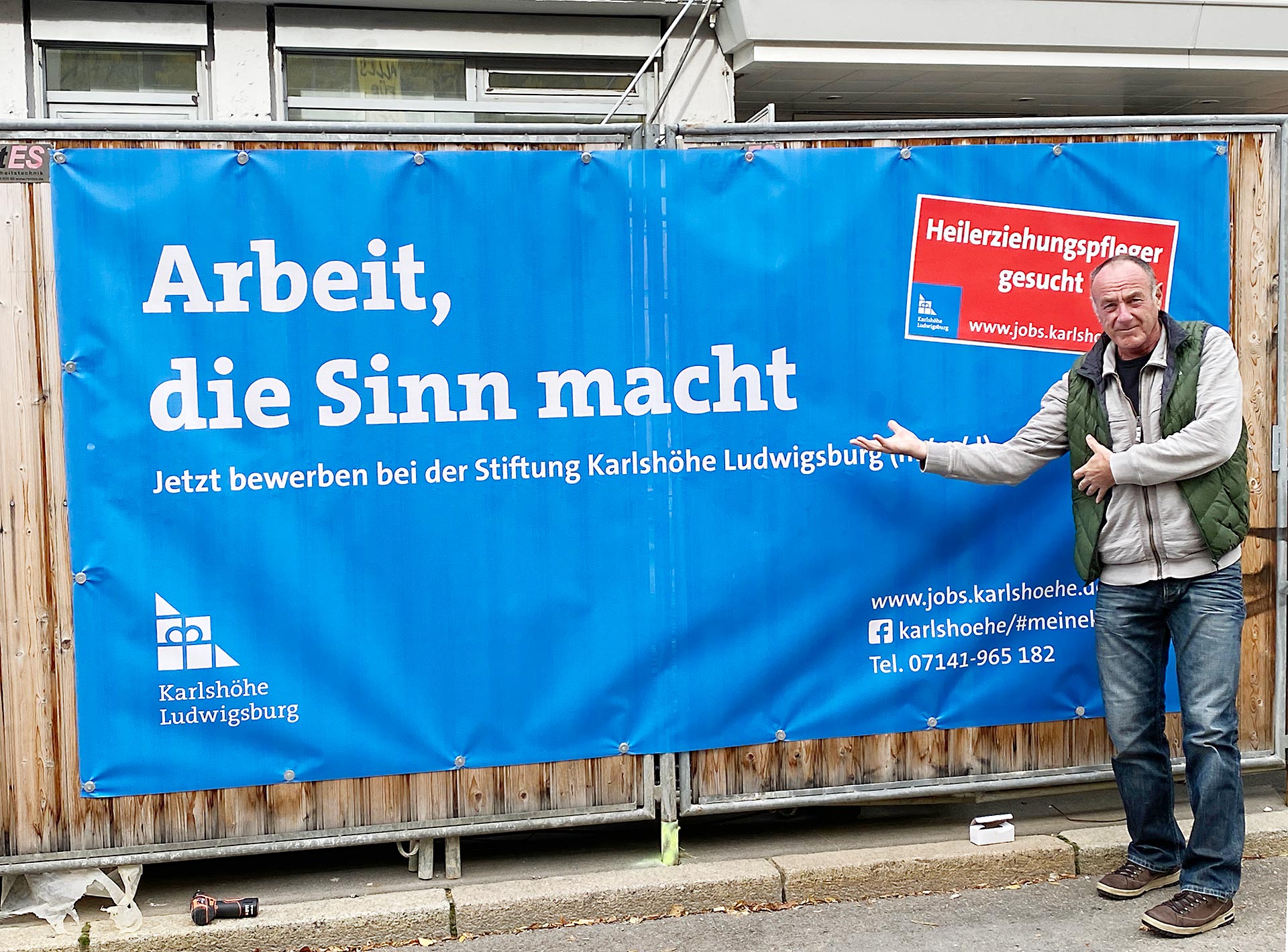 SB Kom-Mitarbeiter Michael Gross hat ein neues Plakat der Kampagne am Bauzaun der KSK Ludwigsburg montiert (Foto: SB Kom)